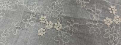 Scattered embroidered blossoms on a soft white ground.