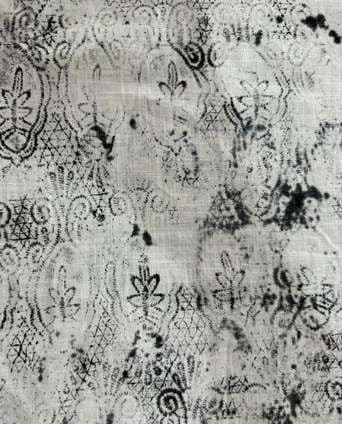 Faded block-printed motifs broken up by dark ink blotches.