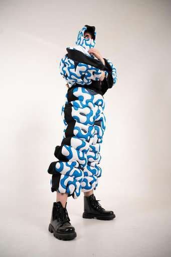 Final garment: a cobalt squiggle-print puffed suit, standing.