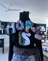 A black hoodie with oversized puffed letters stacked across the back.