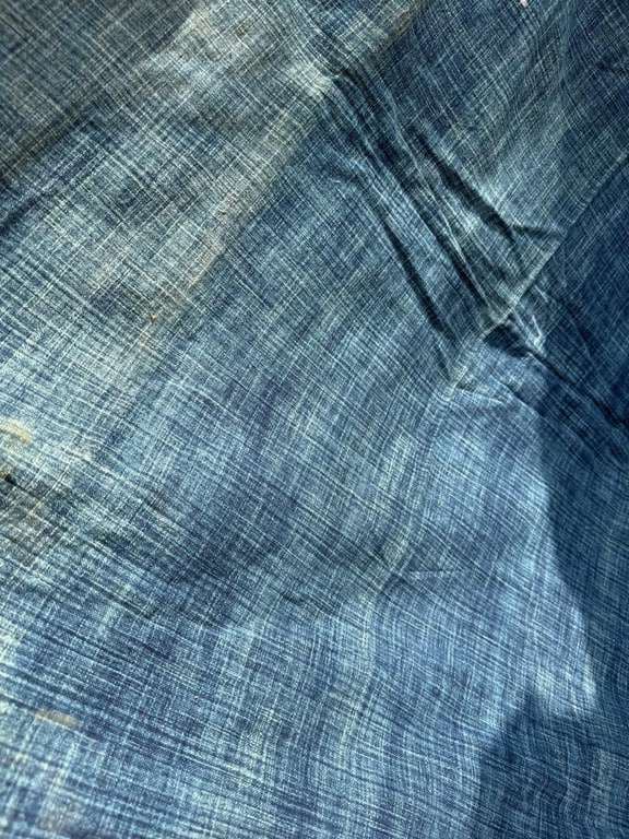 Blue fabric with streaked, uneven colour from a mix of Bagru dye and bleach.