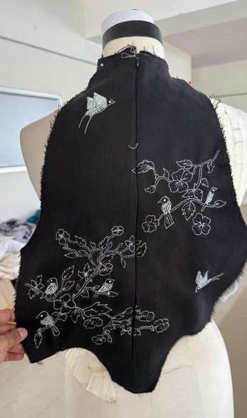 The back of the black corset showing zari embroidery of birds on branches.